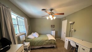 A bedroom with a bed, desk, dresser, and a ceiling fan. - Big family friendly house Close to Texas A&M (Bryan)