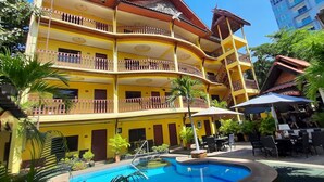 A multi-story hotel with balconies, a swimming pool, and outdoor seating areas. - Phratamnak Inn (Pattaya)
