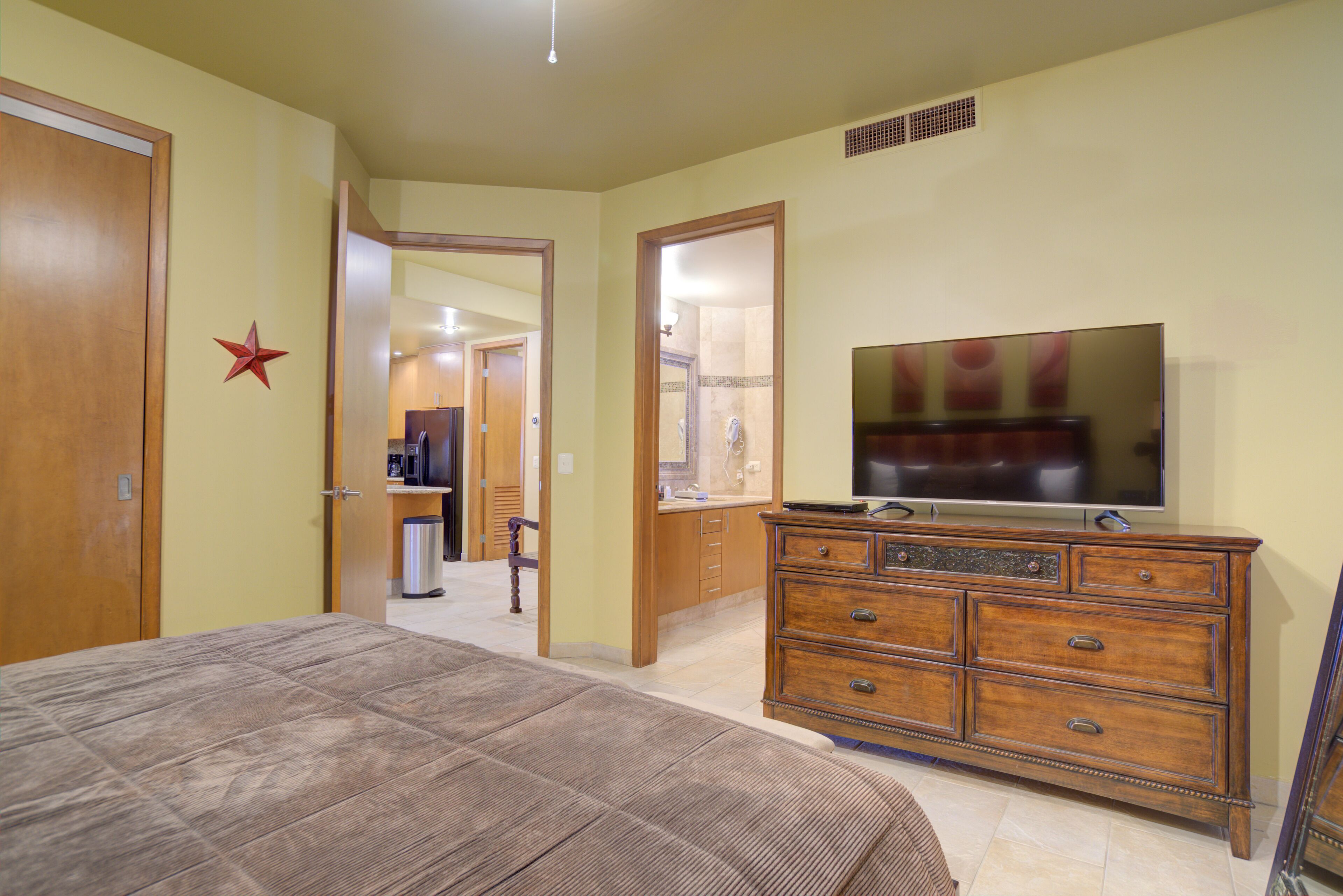 Une chambre à coucher avec un lit, une commode et un téléviseur.