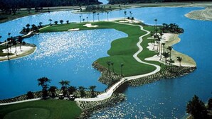 A golf course with a water hazard, sand bunkers, and a winding path.