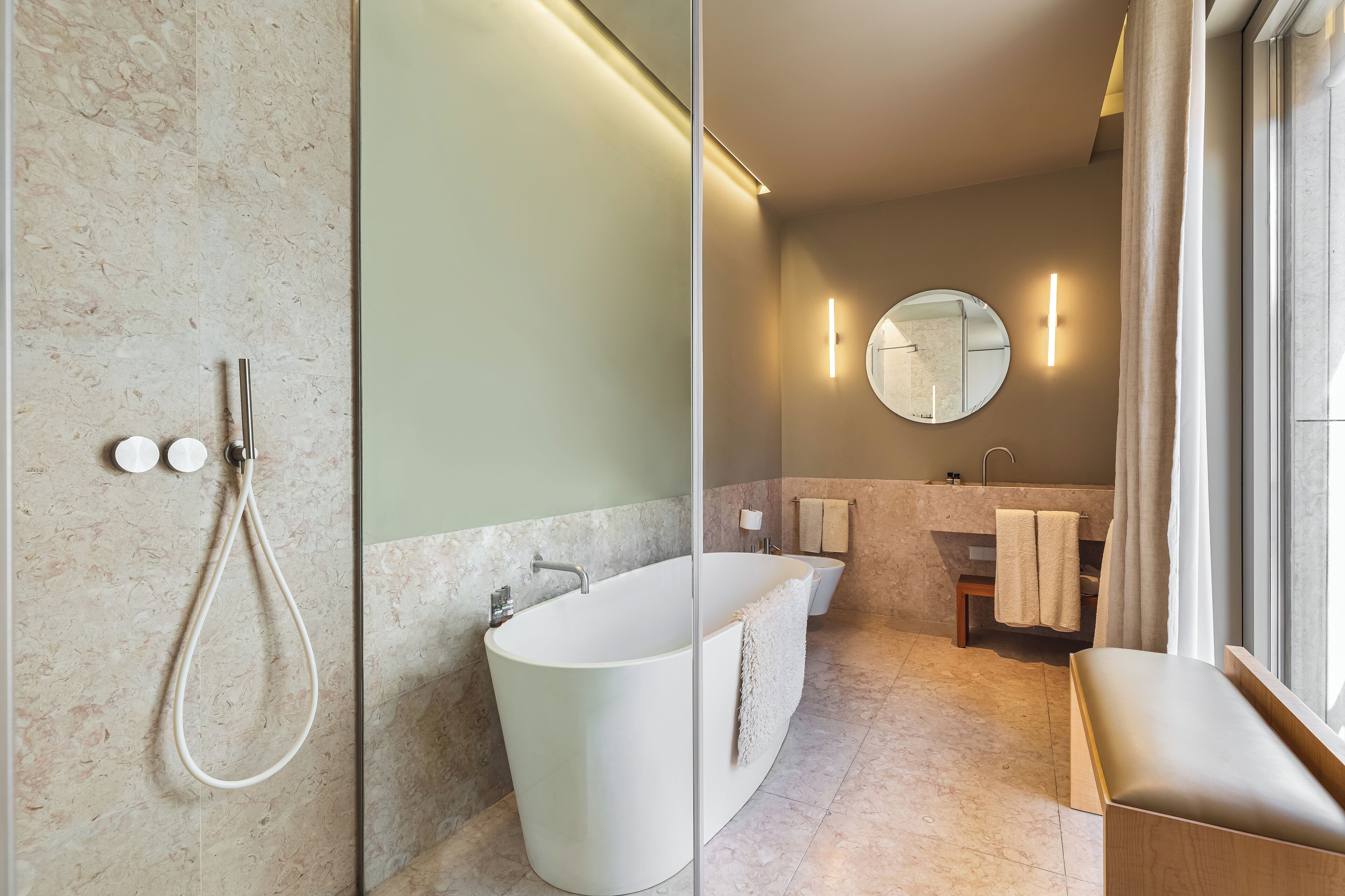 Un bagno moderno con una vasca freestanding, una doccia con pareti in vetro e un mobile lavabo con specchio.