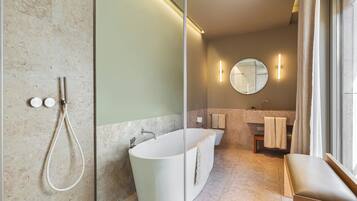 Un bagno moderno con una vasca freestanding, una doccia con pareti in vetro e un mobile lavabo con specchio.