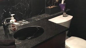 A bathroom with a black marble sink, a white toilet, and a mirror above the sink. - Charming 2 Bdrm Condo, Peaceful Setting on Bus Line/Vail #011008 (Vail)