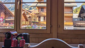 A wooden-framed window with a view of traditional wooden buildings and mountains. - Hotel Bären (Adelboden)