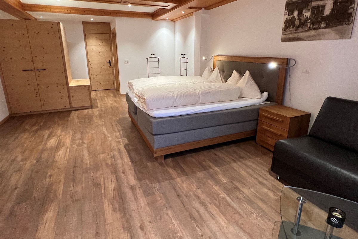 A bedroom with a bed, bedside tables, a wardrobe, and a mirror.