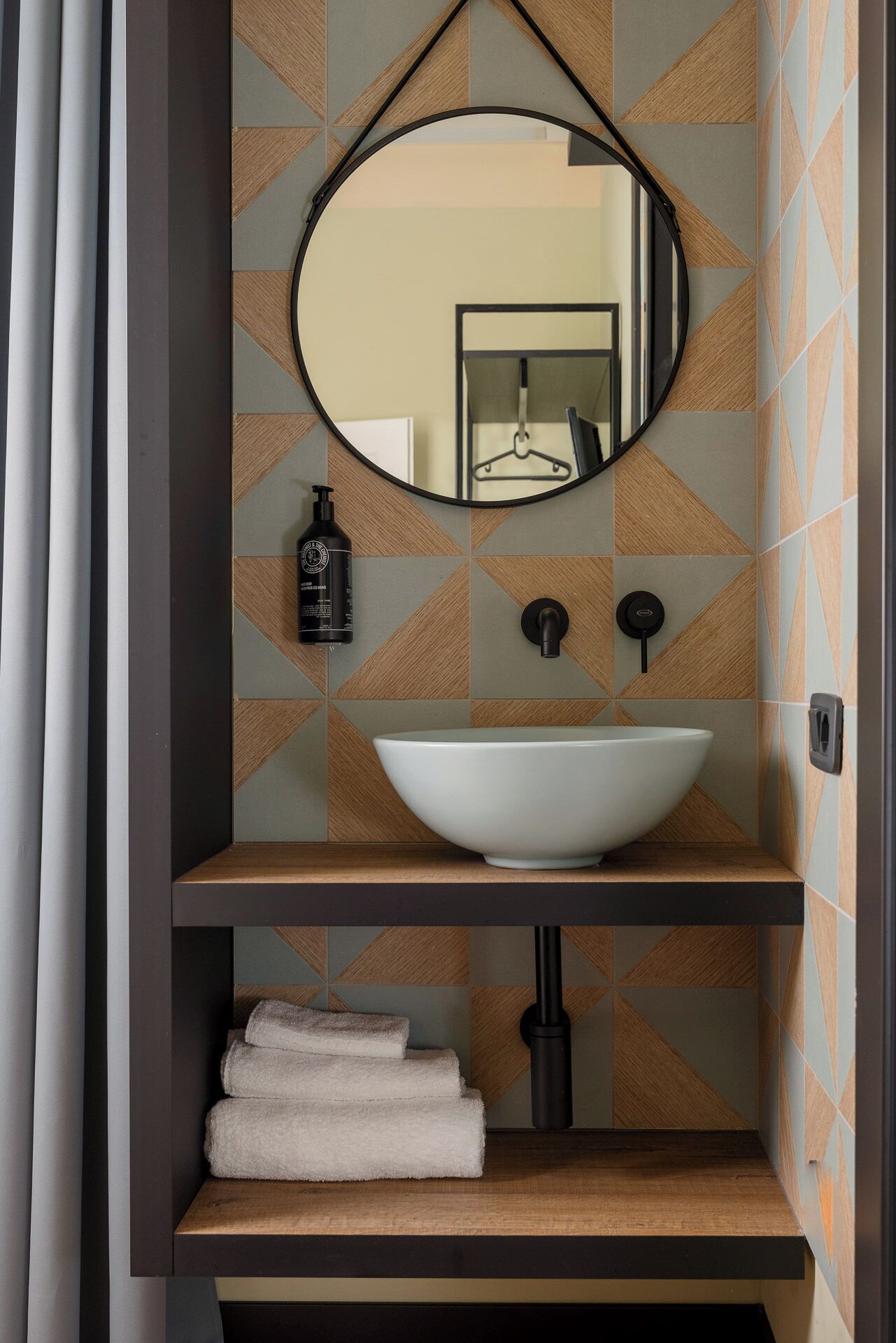 Une salle de bain avec un grand lavabo ovale, un miroir et un porte-serviettes.