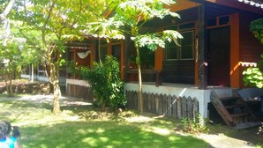 A wooden house with a porch, surrounded by trees and a grassy yard. - Bamboo Bungalow Thong Nai Pan Yai (Ko Pha-ngan)