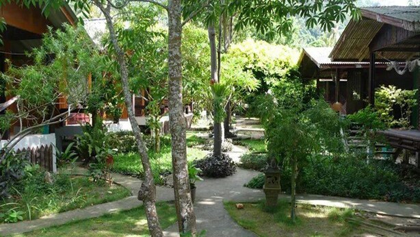 A garden pathway leading to a rustic wooden structure with a thatched roof. - Bamboo Bungalow Thong Nai Pan Yai (Ko Pha-ngan)