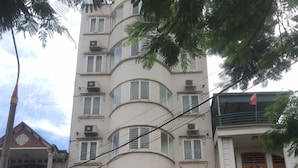 A hotel with a prominent entrance, multiple floors, and a visible staircase leading to the entrance. - Quynh Trang Hotel (Hai Phong)