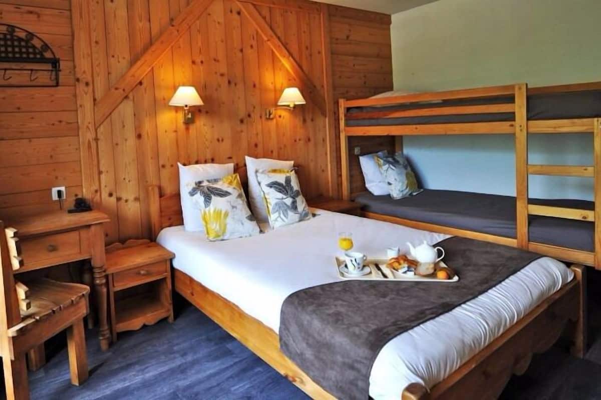 Ein Zimmer mit Holzboden, einem Etagenbett, einem Schreibtisch und zwei Nachttischlampen.
