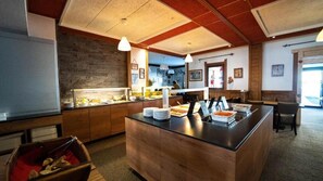 A restaurant with a wooden counter, buffet area, and seating. - Hôtel Les Carrettes (Valmeinier)