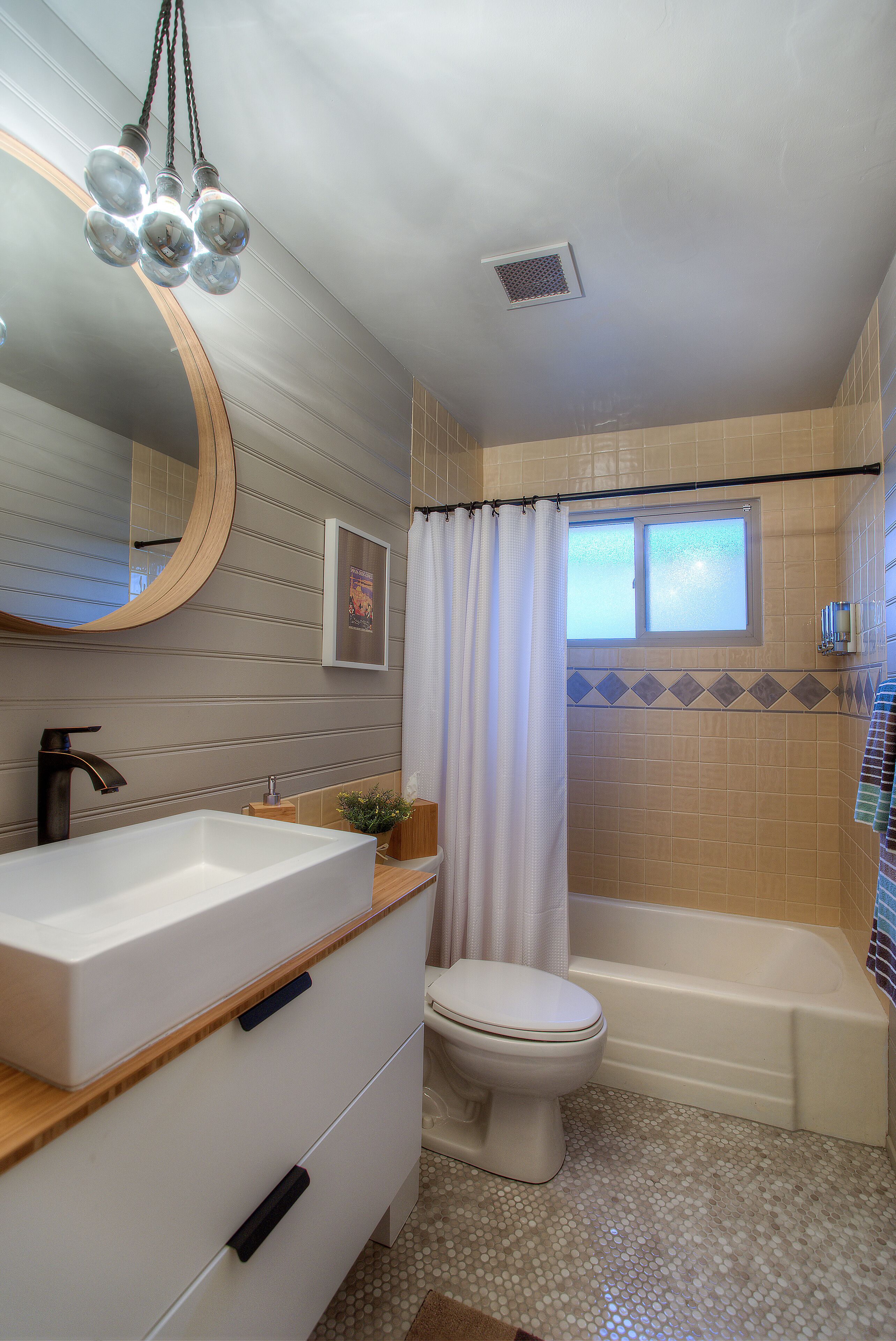 A bathroom with a white sink, a toilet, a bathtub, and a shower curtain.