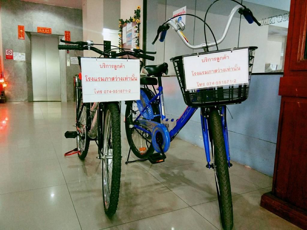 Dos bicicletas con cestas, cada una con un cartel que muestra información de contacto.