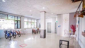 A spacious lobby with bicycles, a reception desk, and seating areas. - Pasawang hotel (Hat Yai)
