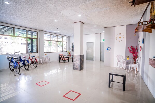 Un hall d’entrée spacieux avec des vélos, un comptoir d’accueil et des espaces de détente.