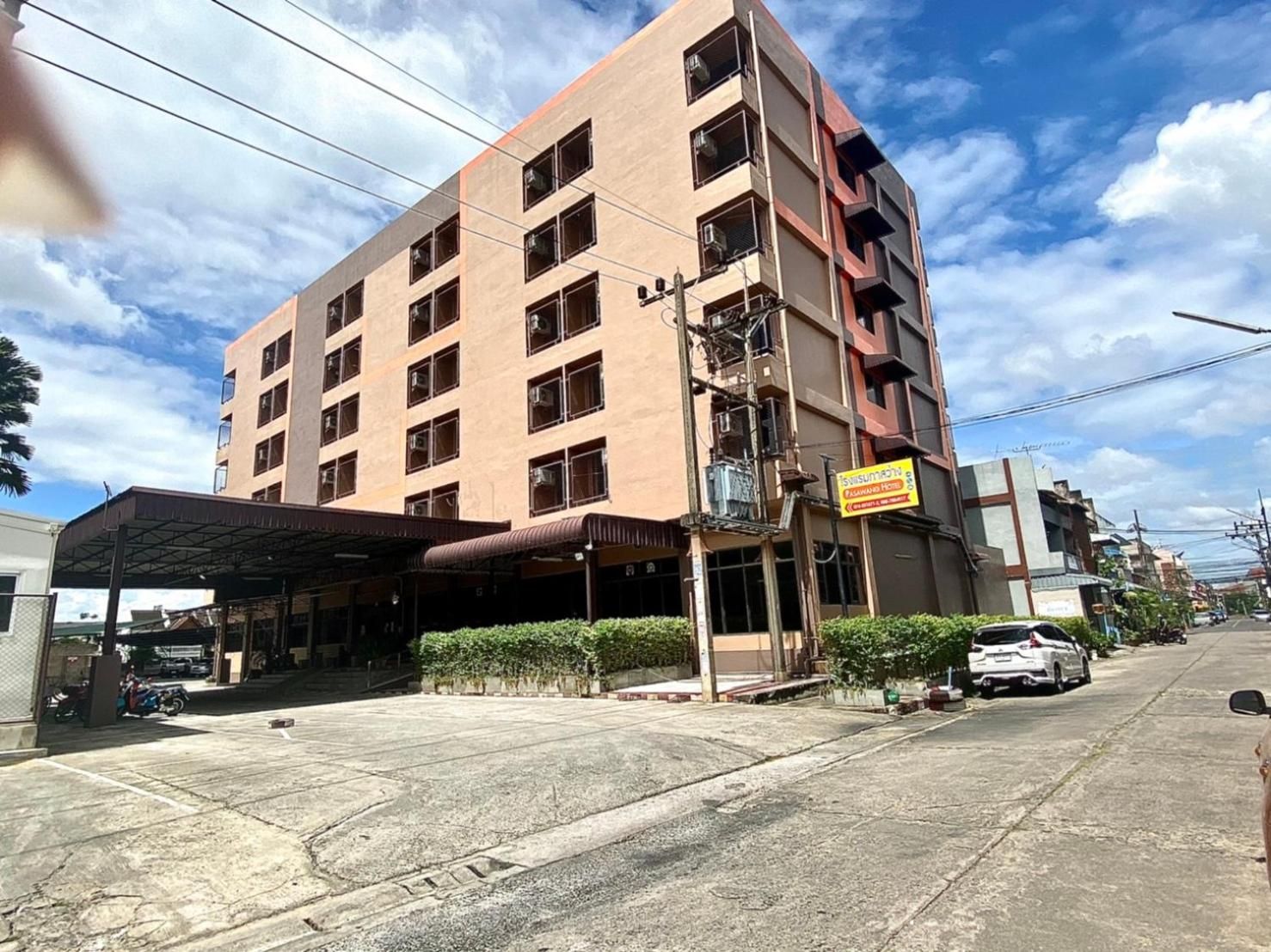 Un edificio de varios pisos con un acceso cubierto y un cartel que indica un comercio.