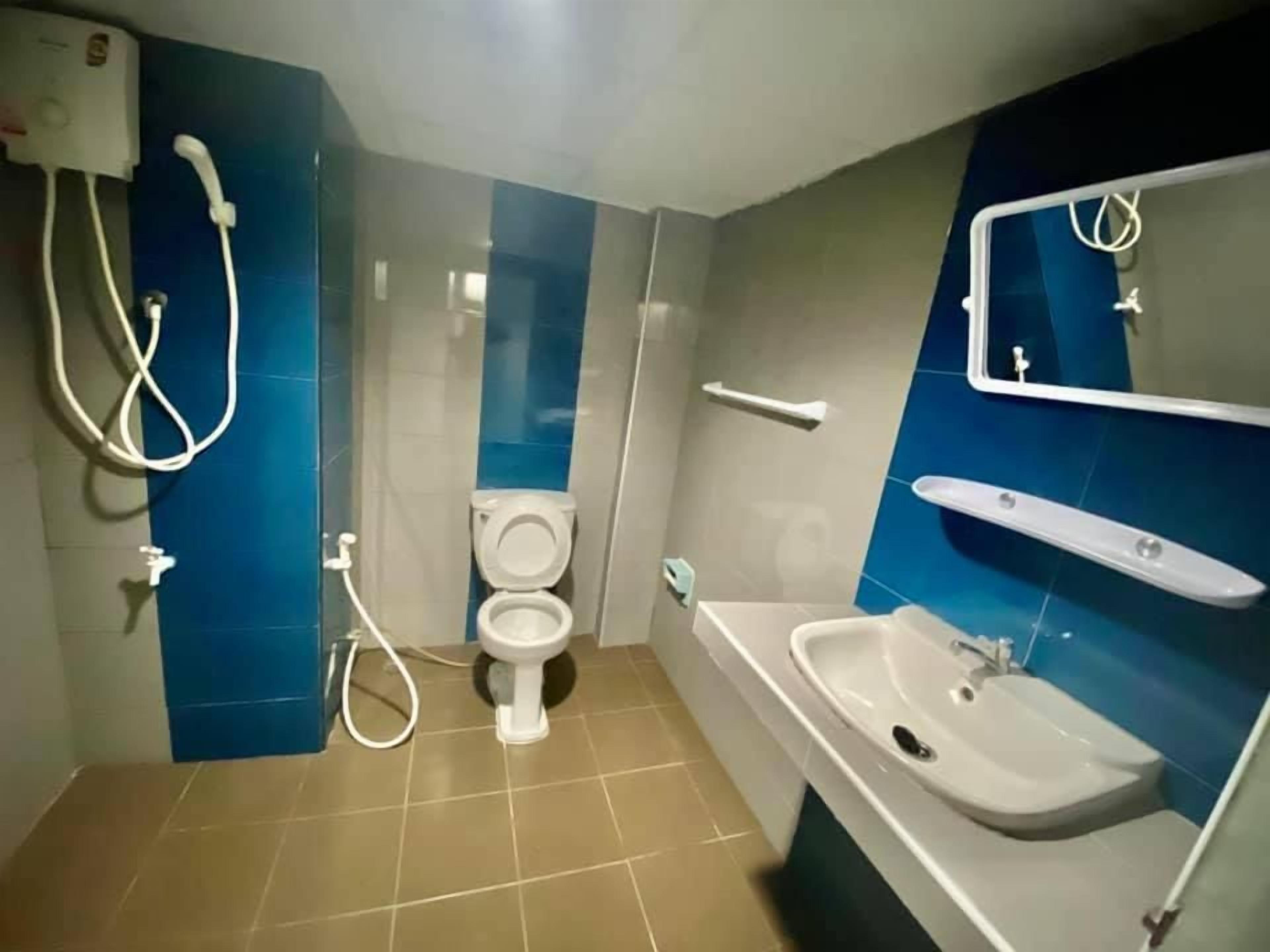A bathroom with a toilet, bidet, and a sink.
