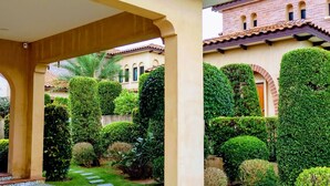 A courtyard with a brick building, a pergola, and well-manicured hedges. - Estella Pool Villas Pattaya (Sattahip)