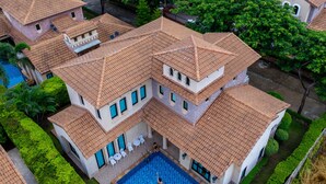 A large, multi-story house with a swimming pool, surrounded by well-maintained gardens and trees. - Estella Pool Villas Pattaya (Sattahip)