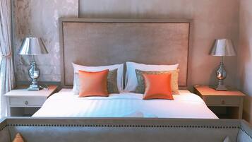 A neatly made bed with two pillows, a headboard, and two bedside tables with lamps.