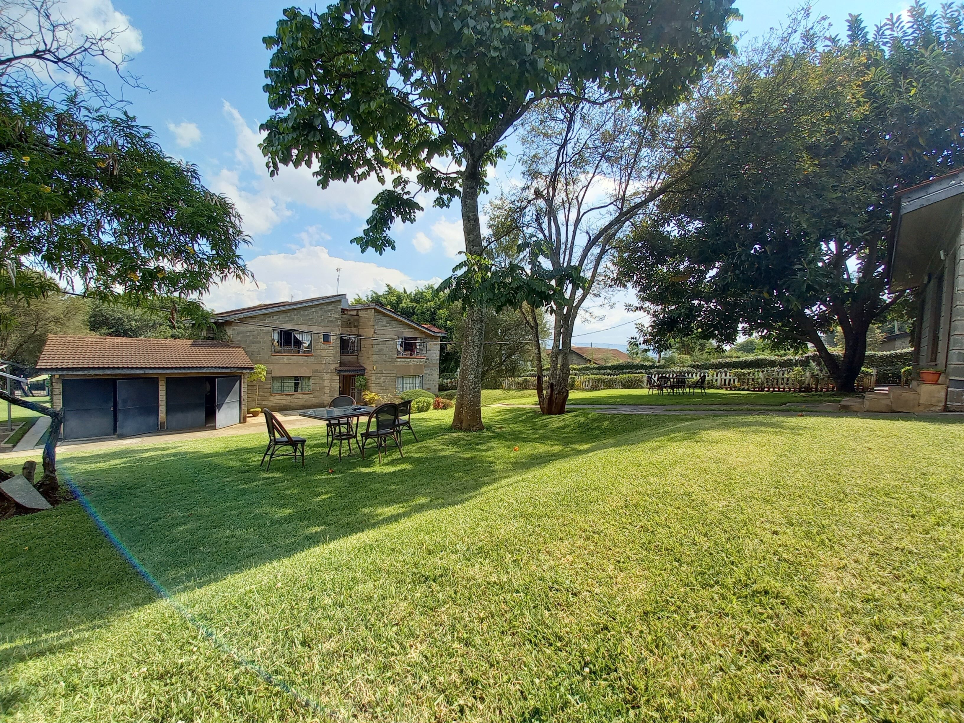 A house with a two-story structure, a covered patio, and a well-maintained lawn.