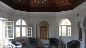 A room with a high ceiling, arched windows, and a chandelier. - Cairwan Hotel (Al-Karak)