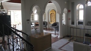 A grand lobby with high ceilings, ornate columns, and a central reception desk. - Cairwan Hotel (Al-Karak)
