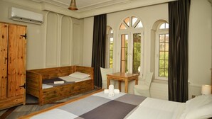 A bedroom with a wooden bed, a wooden table, a chair, and a wardrobe. - Cairwan Hotel (Al-Karak)