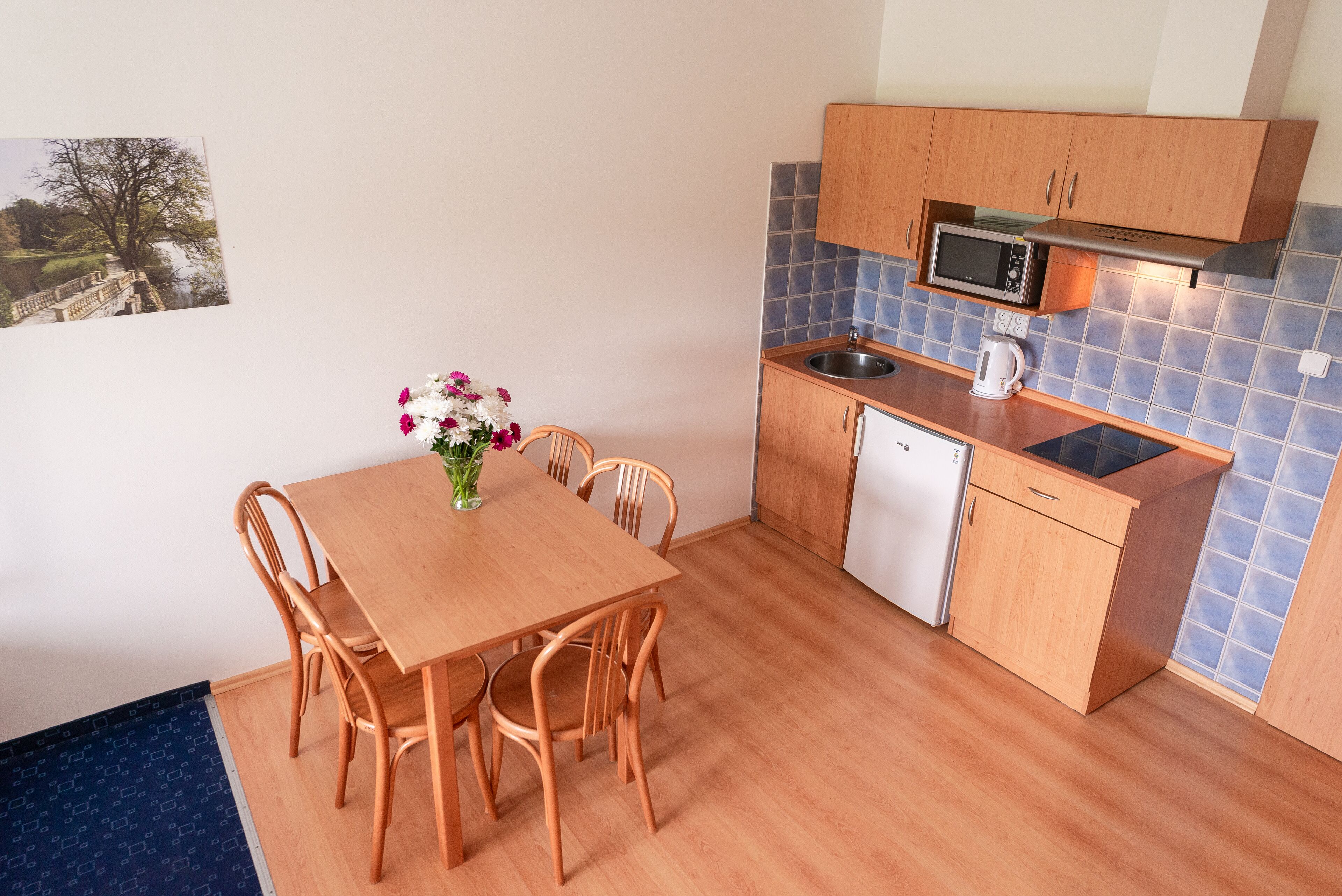 A compact kitchen with wooden cabinets, a microwave, a sink, and a dishwasher.