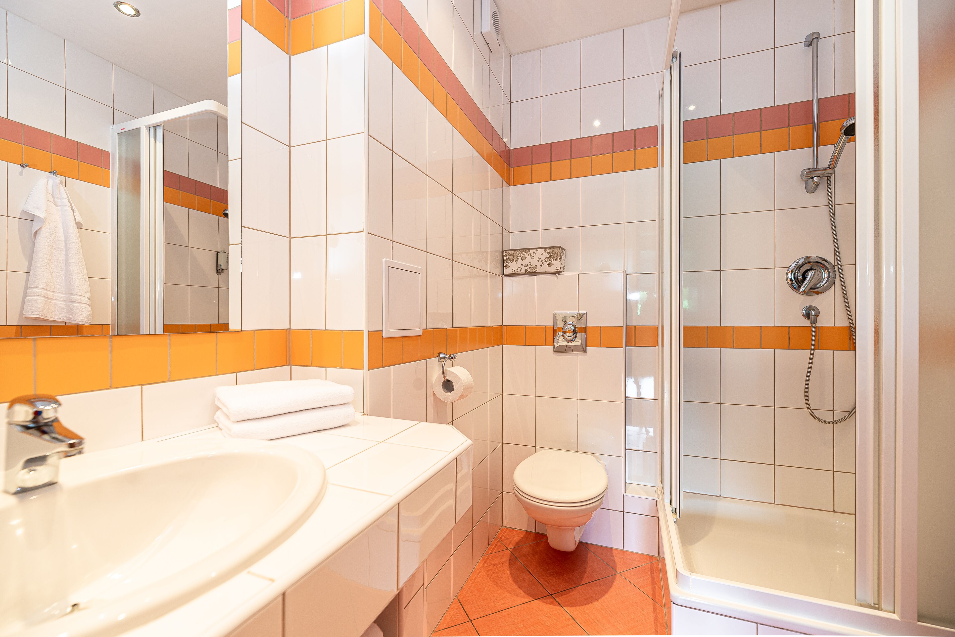 Un baño con lavamanos, inodoro y ducha.