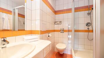 Un baño con lavamanos, inodoro y ducha.
