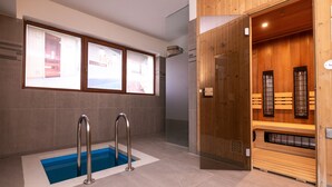 A modern spa area with a pool, wooden sauna, and large windows. - Apartmany Engadin (Bozi Dar)
