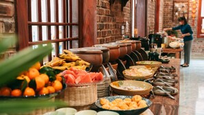 A buffet setup with various food items and serving utensils. - Trang An Heritage Garden (Tay Hoa Lu)
