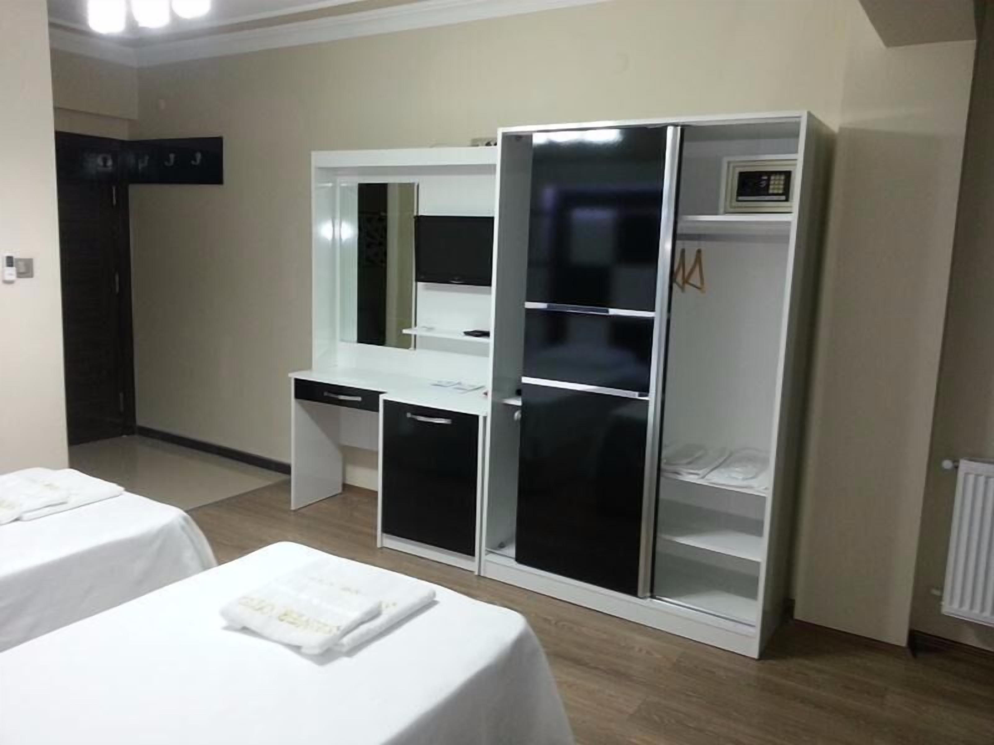 A hotel room with a bed, a desk, and a wardrobe.