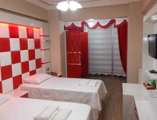 A hotel room with two beds, a desk, and a TV. - Sener Hotel (Pamukova)