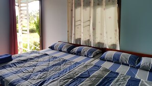 A bedroom with a bed, curtains, and a window. - Ban Mae Resort (Khao Kho)