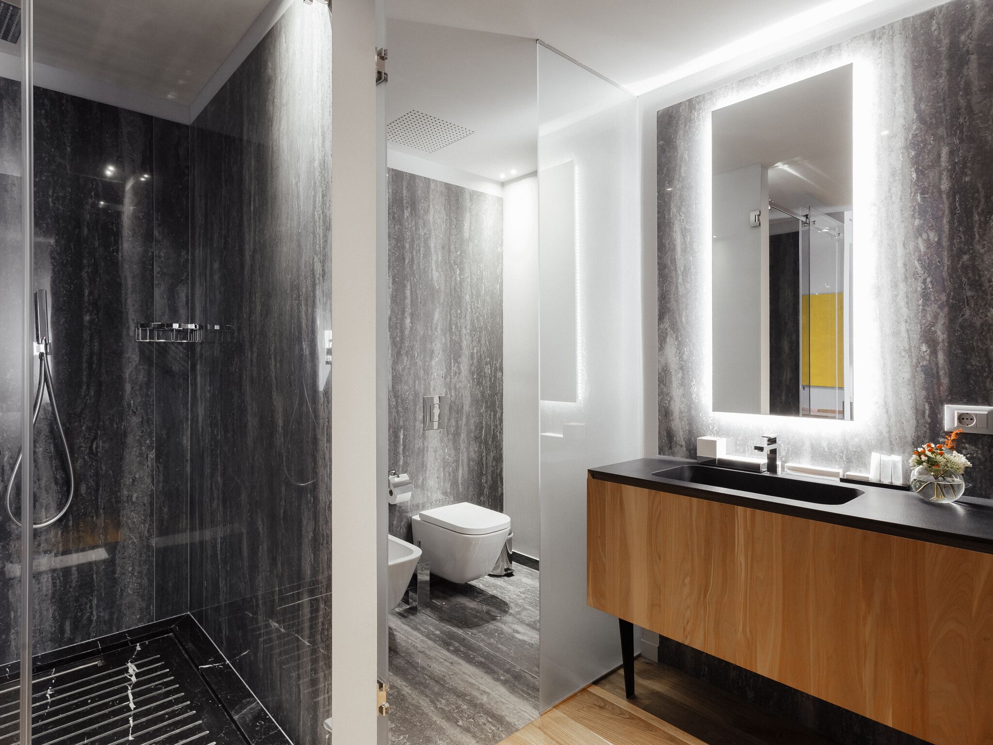 A modern bathroom with a shower, toilet, and vanity.