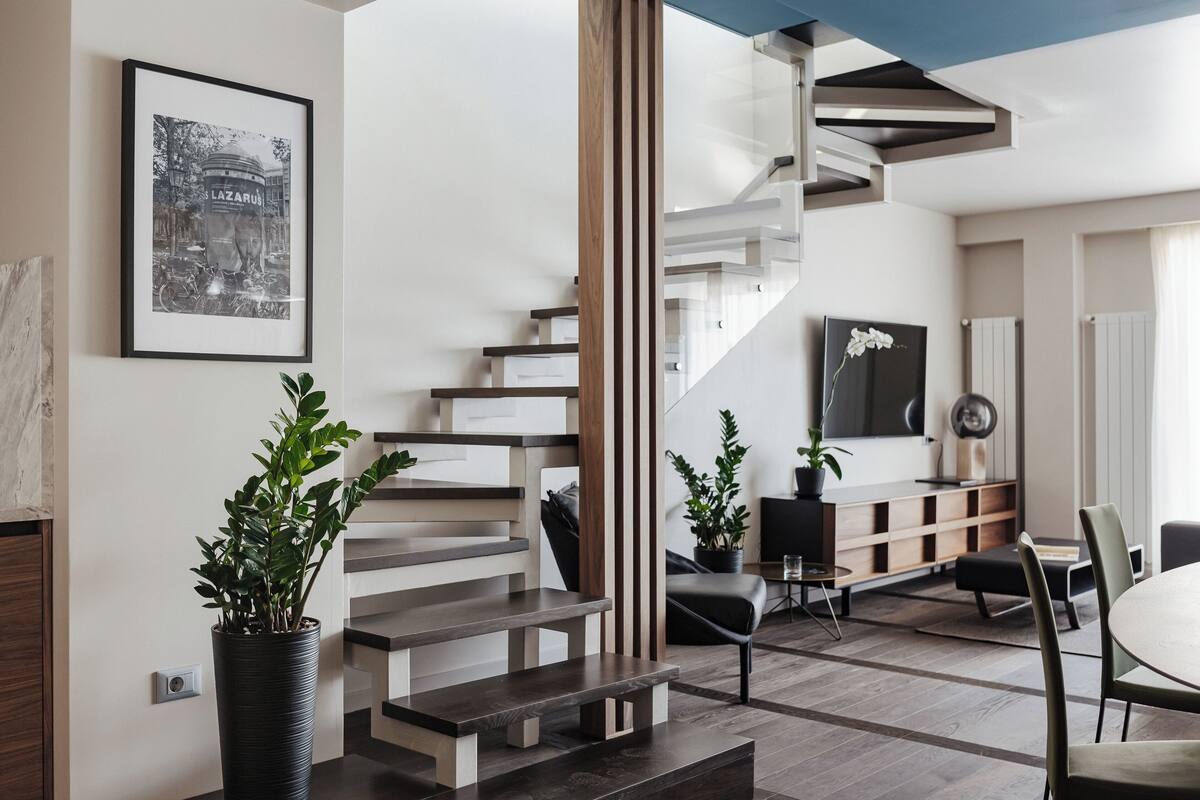 A modern interior with a staircase, a dining area, and a living space.