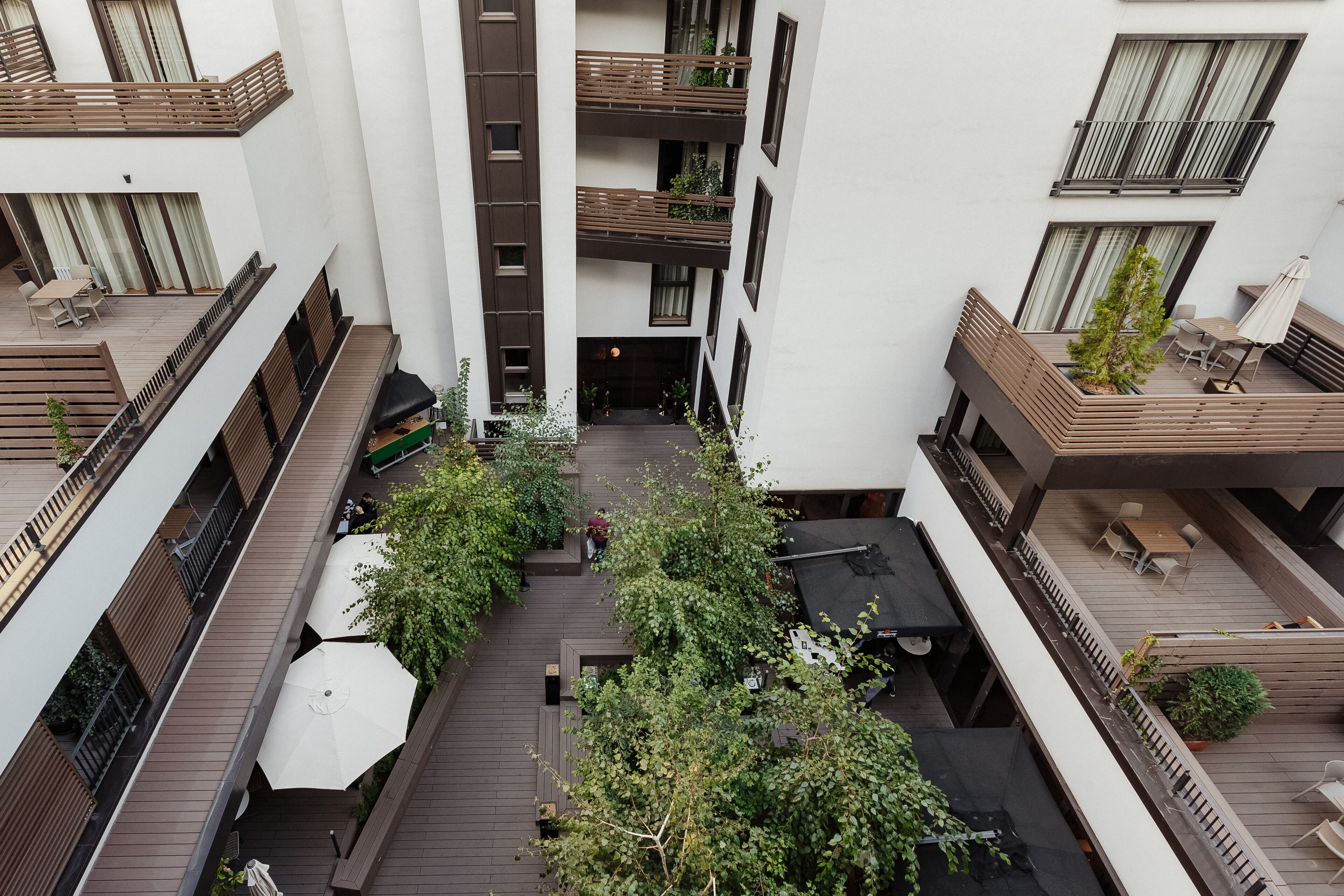 A multi-level courtyard with wooden decking, outdoor seating, and potted plants.