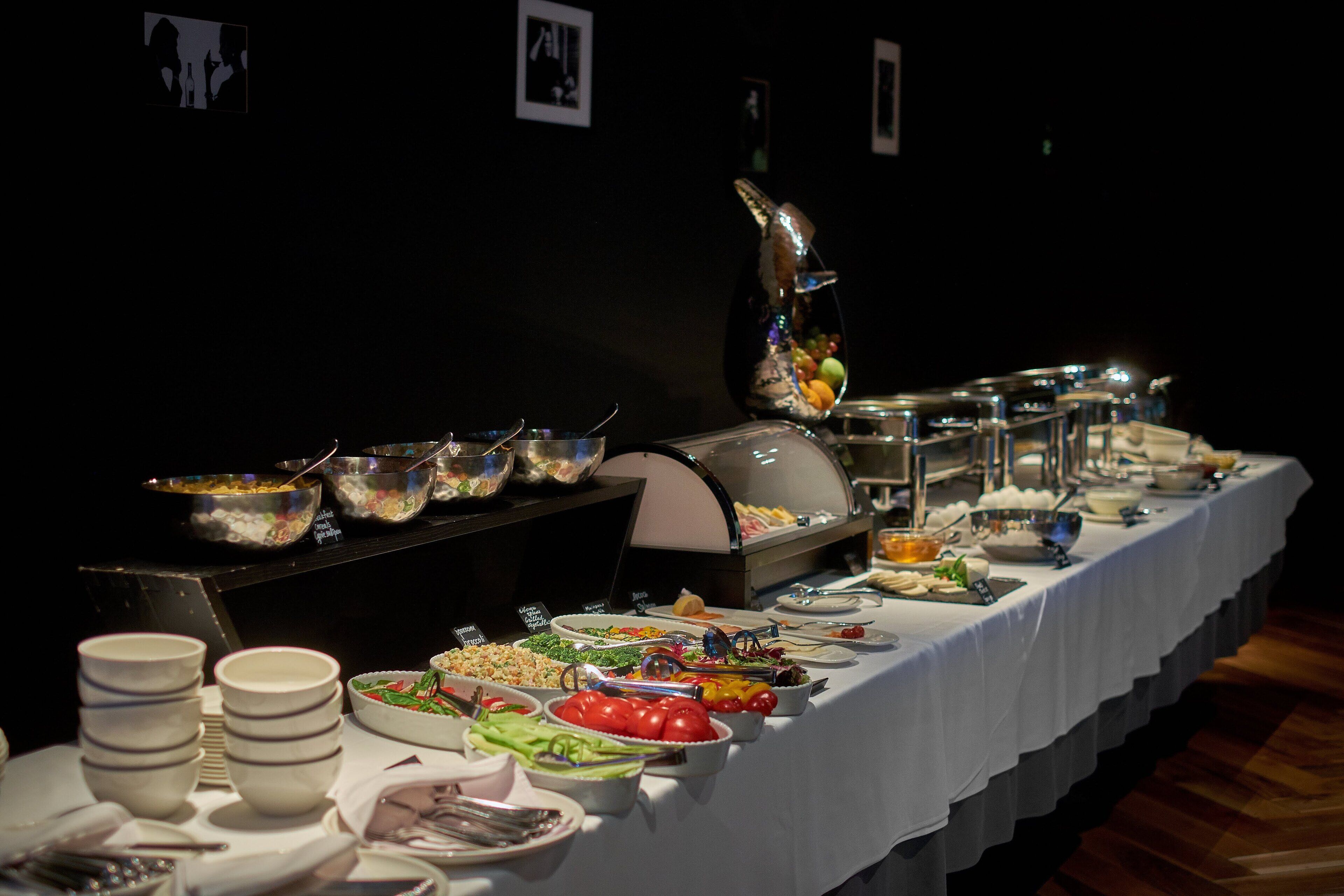Una mesa de buffet con diversos alimentos y cubiertos.