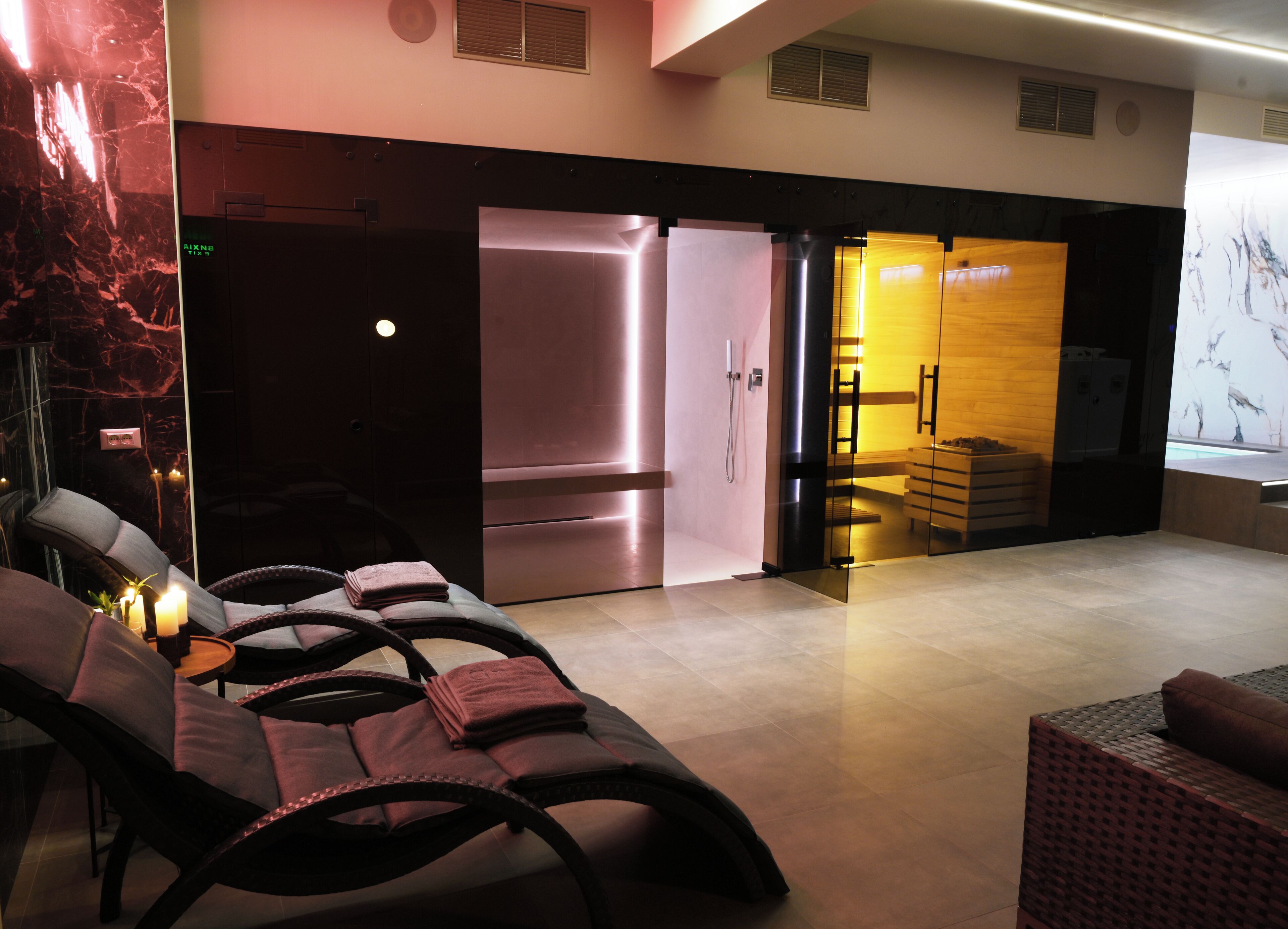 A modern spa area with massage chairs, a sauna, and a reception desk.