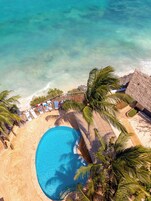 Una piscina al aire libre, sombrillas, sillones reclinables de piscina