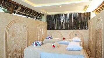 Una habitación con dos camas, cada una con una almohada y una toalla enrollada.