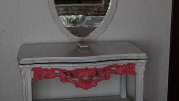 A white vanity with a mirror and red decorative trim.