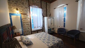A bedroom with a bed, a chair, a wardrobe, and a mirror. - Bergama Tas Konak (Bergama)