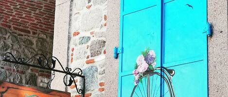 Un edificio con una puerta azul turquesa, un letrero que dice "TAS KONAK" y un muro de piedra con un arco de ladrillo.