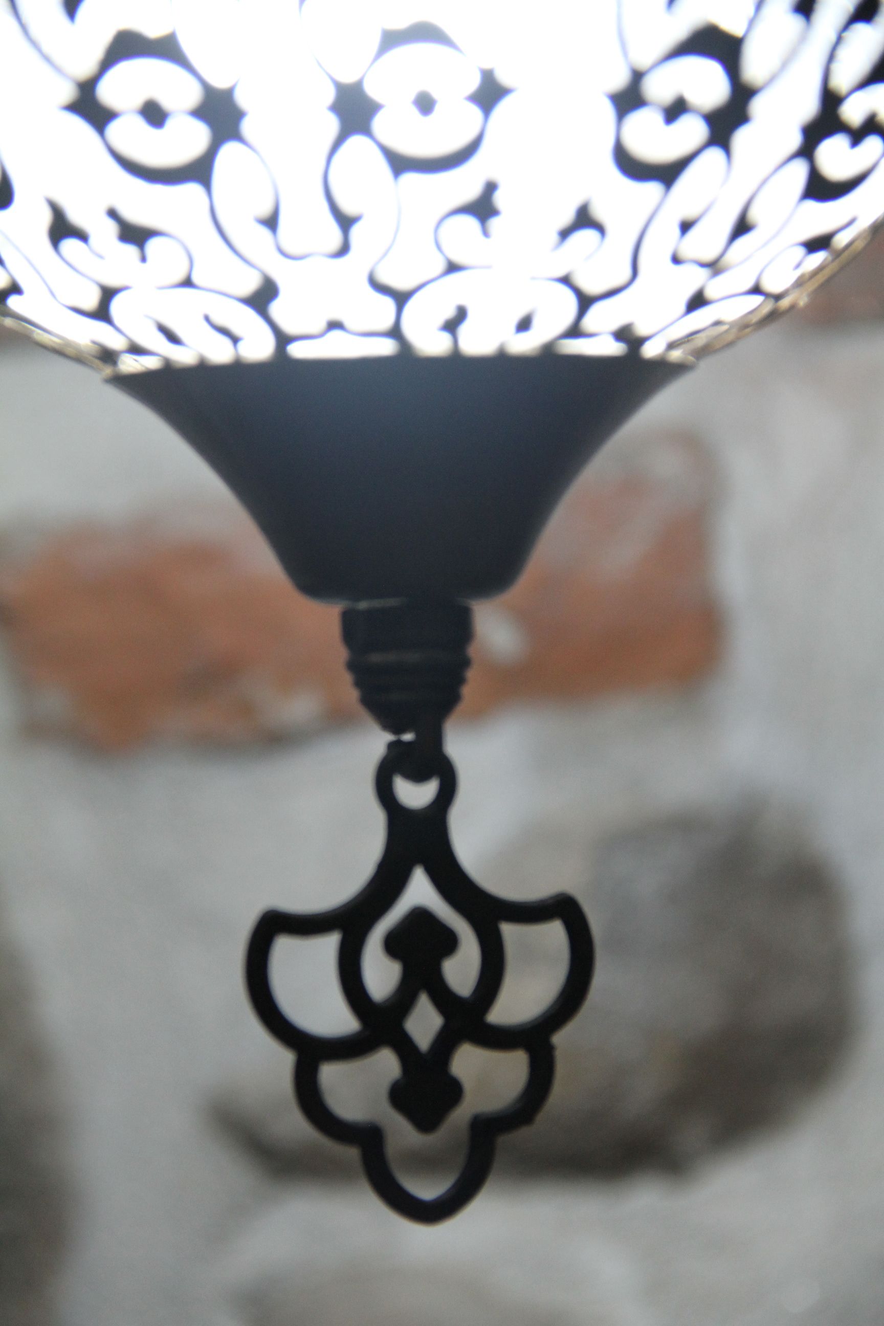 A close-up of a decorative metal light fixture with an ornate design.