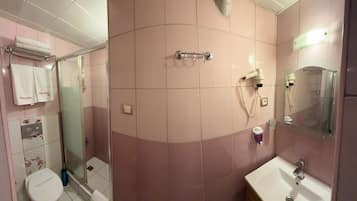 Un bagno con doccia, WC e lavandino.