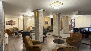 A spacious lobby with high ceilings, stone pillars, and modern lighting fixtures. - Buyuk Hotel (Kayseri)