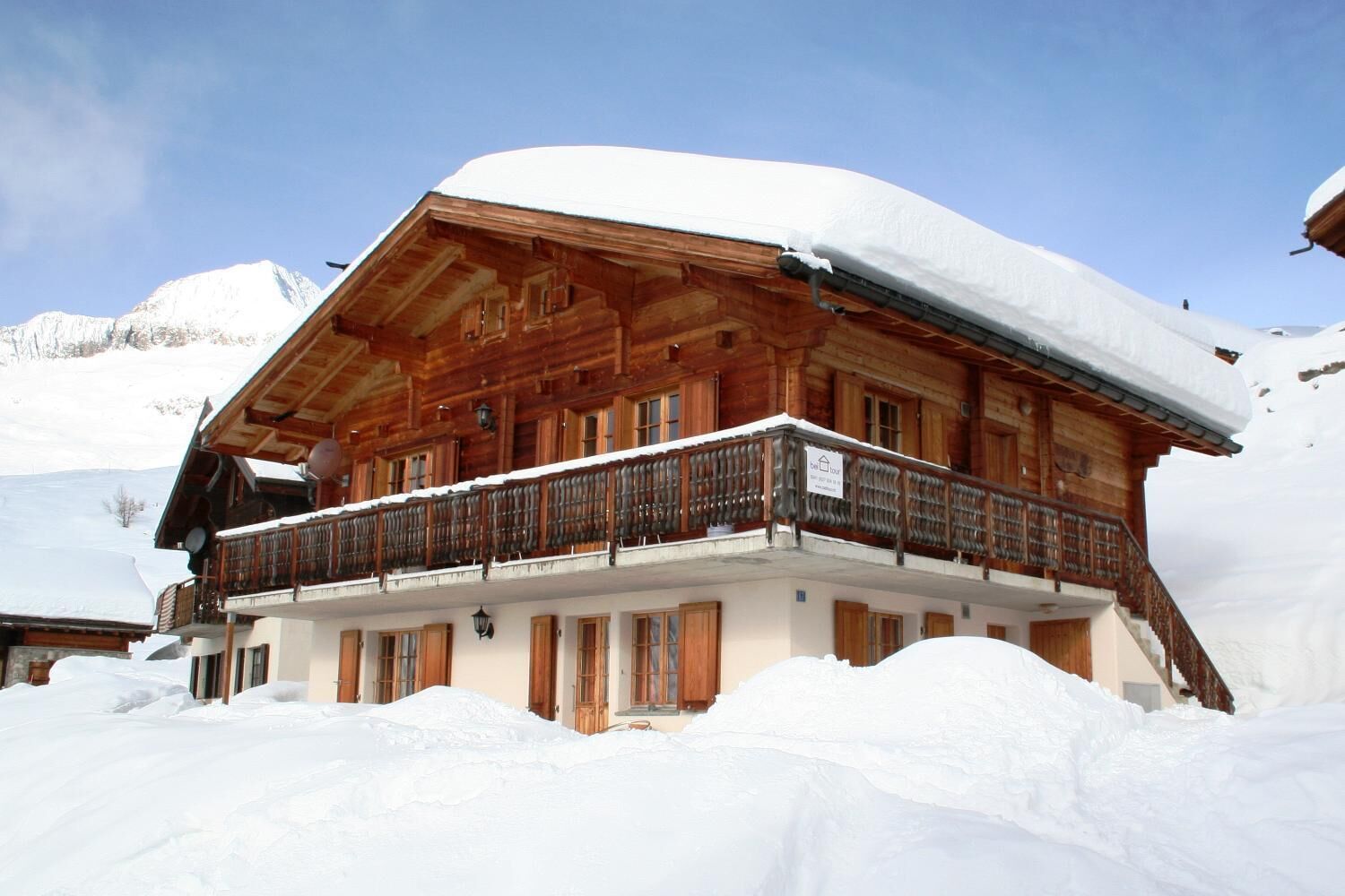 Eine Holzhütte mit Balkon, umgeben von Schnee.